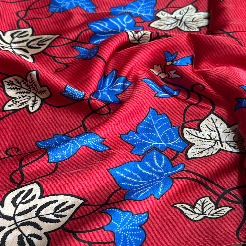 Close-up of red fabric with blue and beige floral patterns
