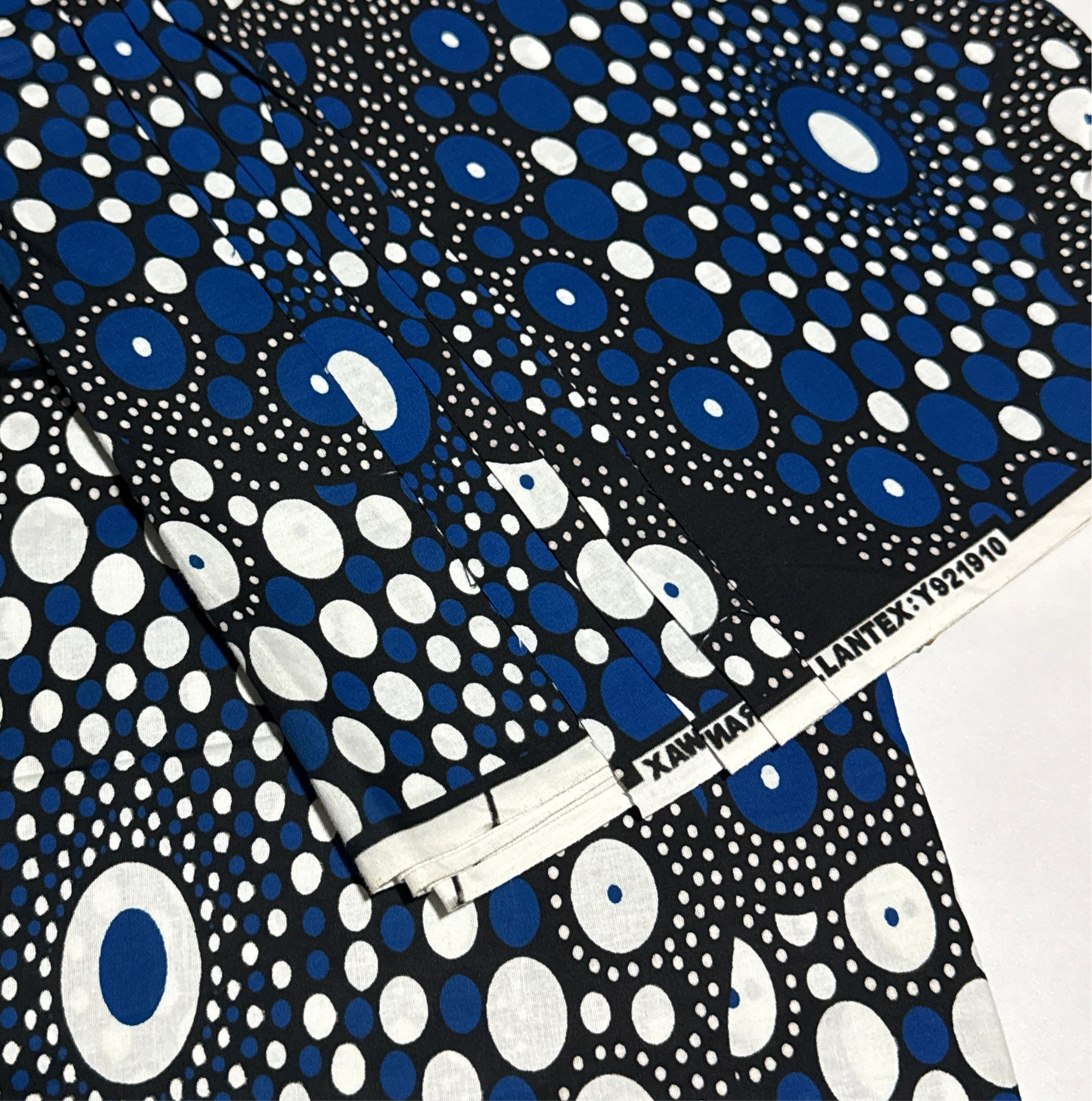 Close-up of blue, white, and black patterned fabric with a visible brand label.