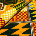 Close-up of colorful fabric with geometric patterns in yellow, red, black, and white.
