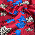 Close-up of red fabric with blue and beige floral patterns