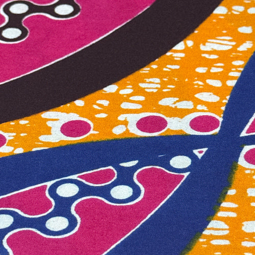 Close-up of a colorful fabric with abstract patterns in purple, blue, orange, and black.
