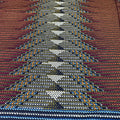 Close-up of a woven fabric with a pattern of interlocking shapes in various colors.