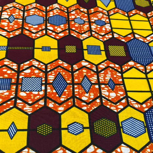 Colorful geometric patterned fabric with hexagonal shapes in orange, yellow, blue, and purple.