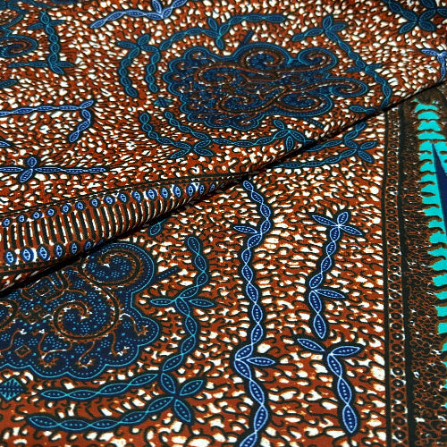 Close-up of a fabric with intricate blue and gold embroidery on a brown background