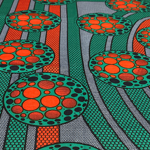 Patterned fabric with circular designs in orange, green, and black.