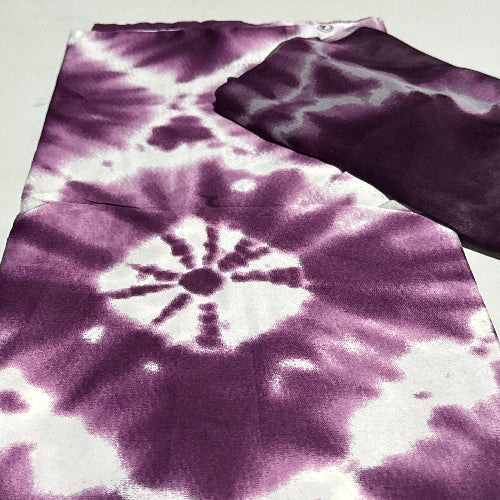 Tie-dye fabric with a purple and white pattern on a light gray background