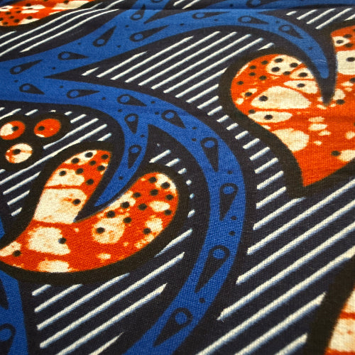 Close-up of a fabric with blue, orange, and black abstract pattern
