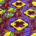 Close-up of vibrant fabric with geometric patterns in blue, yellow, and green.