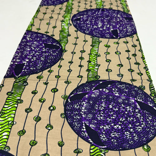 Fabric with a colorful pattern featuring purple and green shapes on a beige background