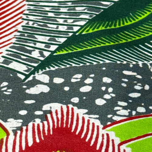 Close-up of fabric with various patterns including green, red, black, and white.