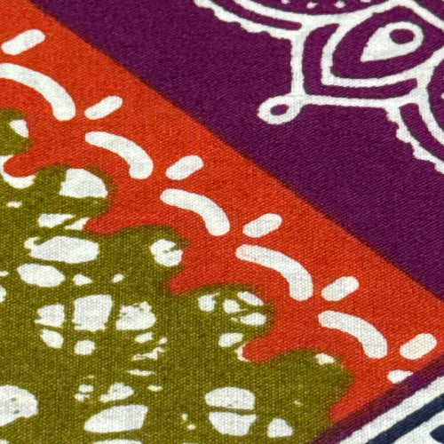 Close-up of a fabric with purple, red, and green patterns