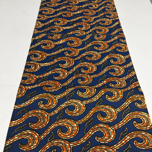 African print fabric with gold and orange patterns on a blue background