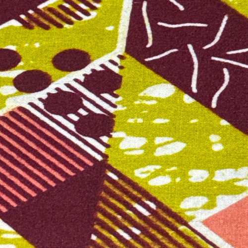 Close-up of a fabric with geometric pattern in purple, green, and brown.