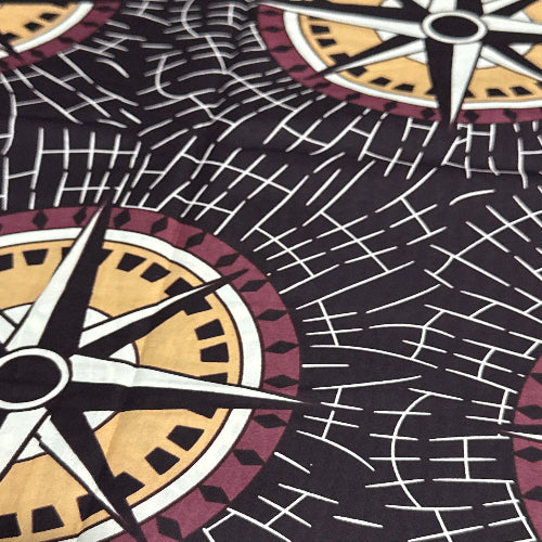 Patterned fabric with compass rose design on a black background