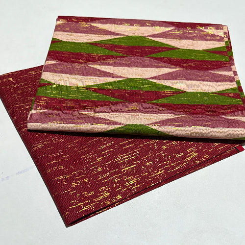 Two patterned books stacked on a white background