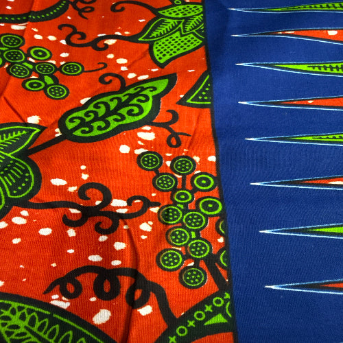 Close-up of colorful fabric with green, black, and orange patterns on a blue background.