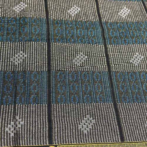 Close-up of a patterned fabric with geometric designs in gray, blue, and black.