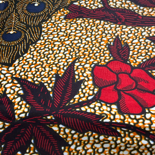 Close-up of a fabric with red floral and black leaf pattern on a textured background