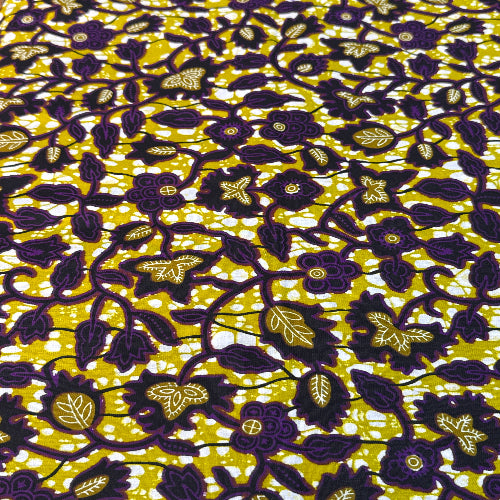 Floral patterned fabric with dark purple flowers on a yellow background