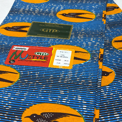 Close-up of fabric with bird pattern and visible brand labels on a blue background
