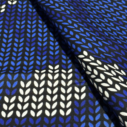 Fabric with blue and white leaf pattern on a black background