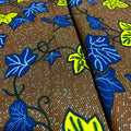 Close-up of fabric with blue and yellow leaf pattern on a brown background