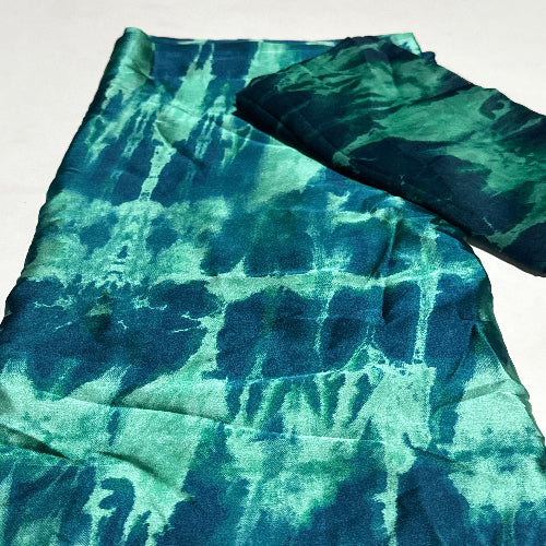 Blue and green tie-dye fabric on a white background