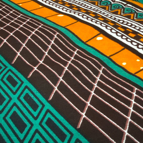 Close-up of a fabric with geometric patterns in orange, black, and teal.