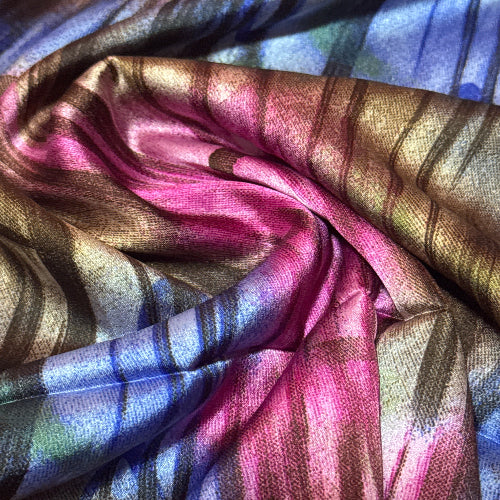 Close-up of colorful fabric with pink, blue, and gold patterns.