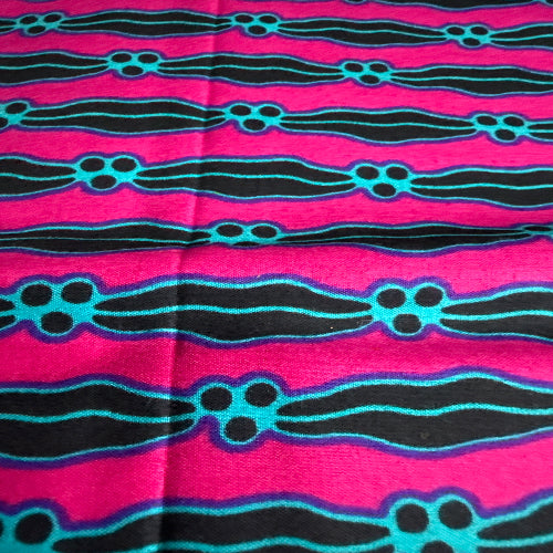 Fabric with black and blue wavy patterns on a pink background