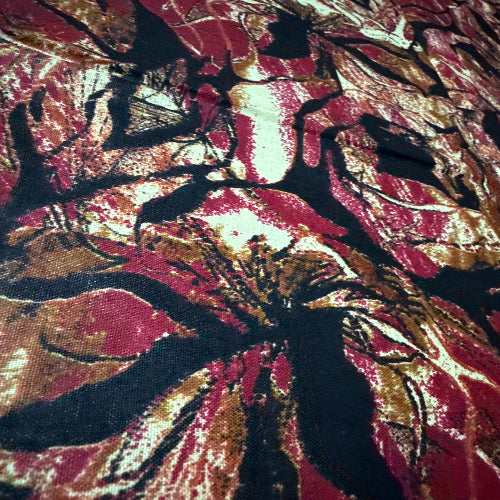 Close-up of a fabric with a floral pattern in red, black, and gold.