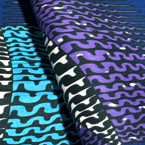 Fabric with wavy pattern in purple, black, and blue.