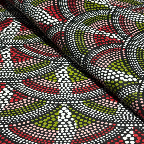 Textile with a pattern of dots and triangles in red, green, and white on a black background
