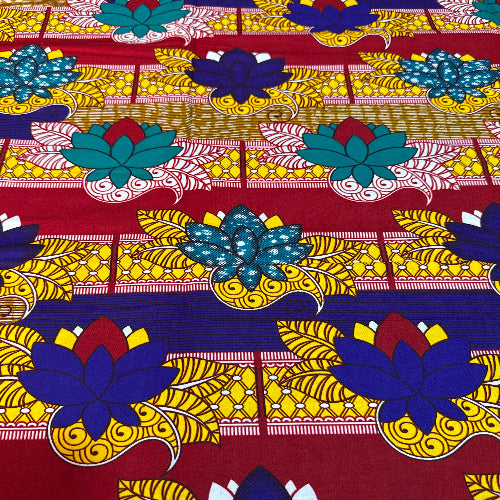 Colorful floral patterned fabric with blue, yellow, and red colors on a red background.