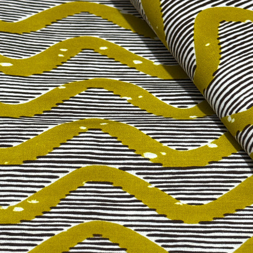 Fabric with yellow wavy patterns on a black and white striped background