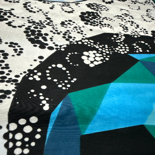 Close-up of fabric with black and white pattern and blue geometric shapes