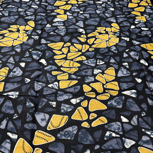 Patterned fabric with yellow and blue shapes on a black background