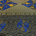 Patterned fabric with blue and gold geometric designs on a textured background