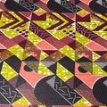 Geometric patterned fabric with a mix of colors including green, pink, black, and brown.