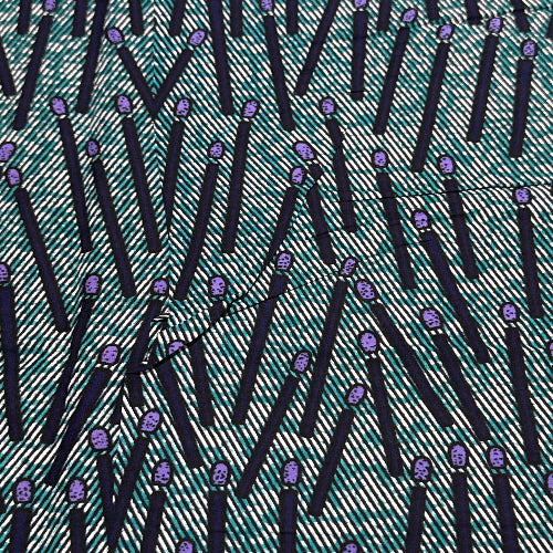 Patterned fabric with black and white stripes and purple accents on a green background