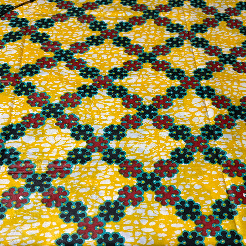 Patterned fabric with black, red, and white flowers on a yellow background