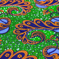 Colorful fabric pattern with blue, orange, and green colors on a green background
