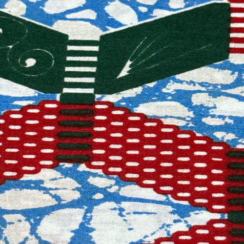 Close-up of a patterned fabric with red, black, and white design on a blue and white abstract background.