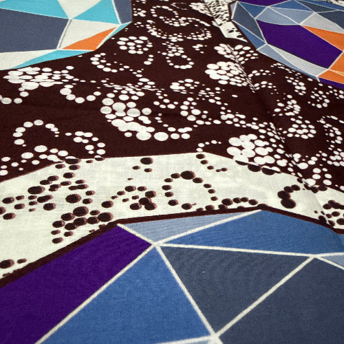 Close-up of fabric with black and white pattern on a blue geometric background