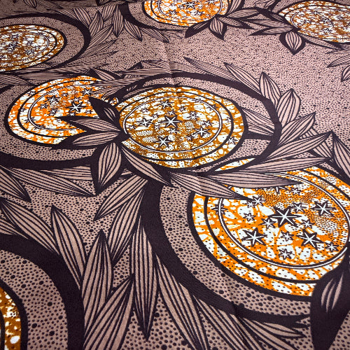 Close-up of a decorative fabric with circular patterns and leaf designs.