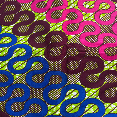 Colorful patterned fabric with pink, purple, and blue shapes on a green and black striped background