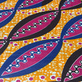 Close-up of a vibrant fabric pattern with purple and blue leaves on a yellow background