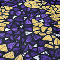 Patterned fabric with yellow and purple shapes on a black background