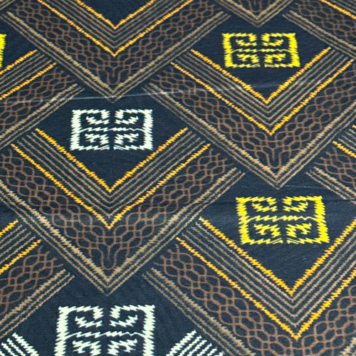 Close-up of a patterned fabric with geometric designs on a dark blue background.