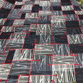 Patterned fabric with black, white, and red lines on a checkered background